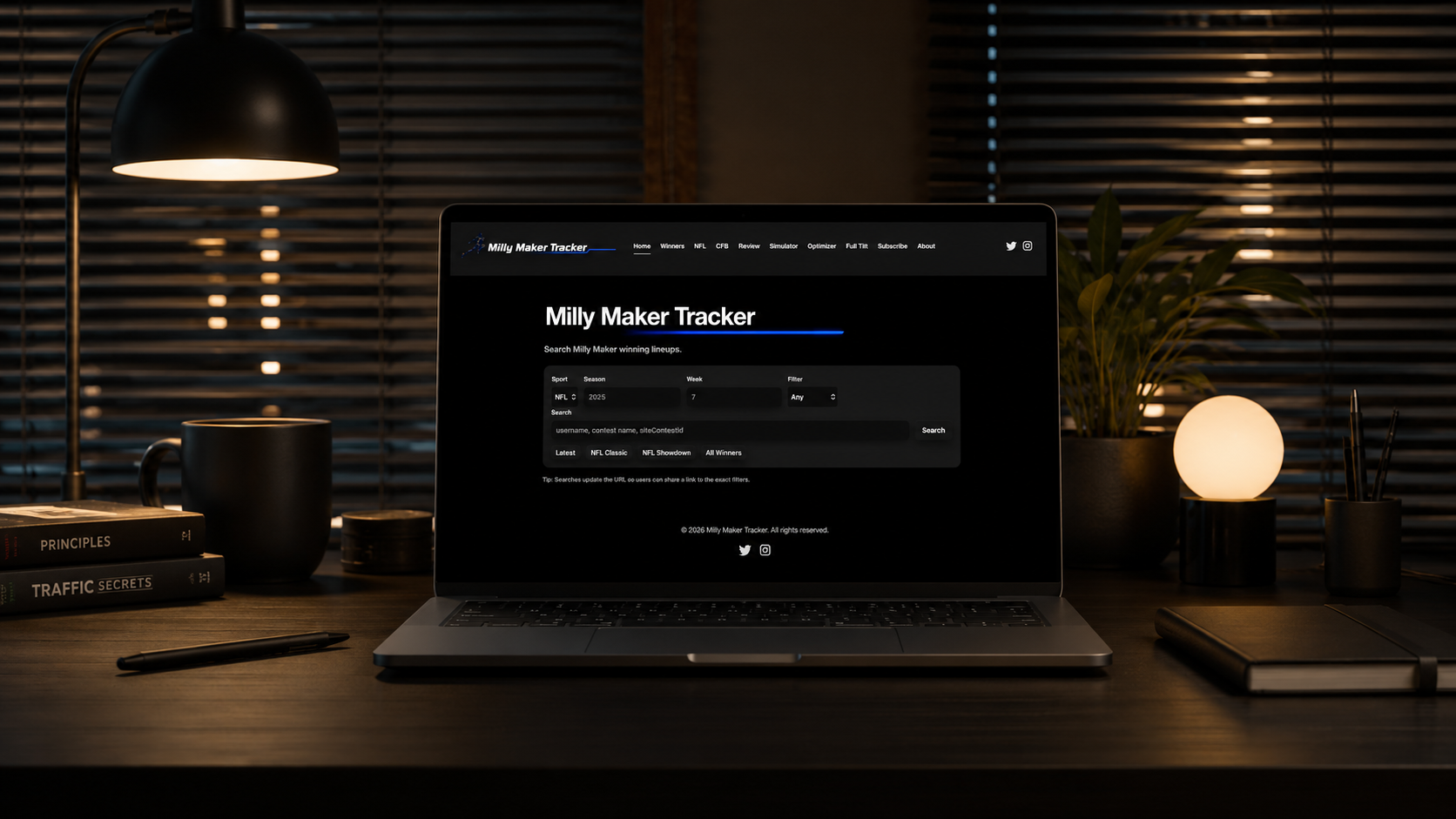 Dark desk setup with Milly Maker Tracker displayed on a laptop screen